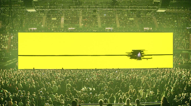 Image depicts bright yellow stage design at the U2 Innocence Experience.
